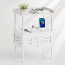 A white two-tier side table with a top shelf and a lower drawer, styled with a small potted plant.