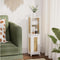 Green sofa with a decorative pillow next to a white cabinet with wicker doors in a room with curtains and a plant.