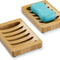Bamboo soap dish with a bar of blue soap on a white background