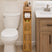 Bathroom with a bamboo wooden storage tower next to a toilet and vanity.