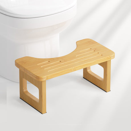 Wooden step stool in front of a white toilet on a white background