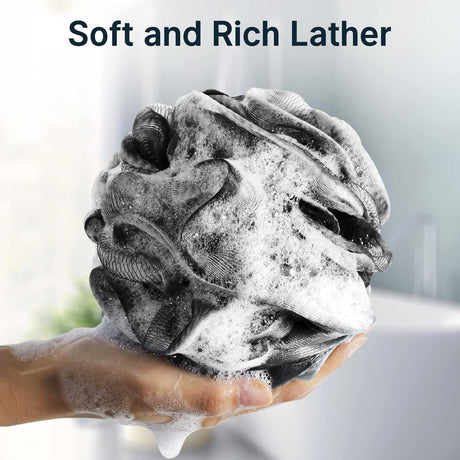 Foamy black loofah held in a hand with text 'Soft and Rich Lather' on a blurred background