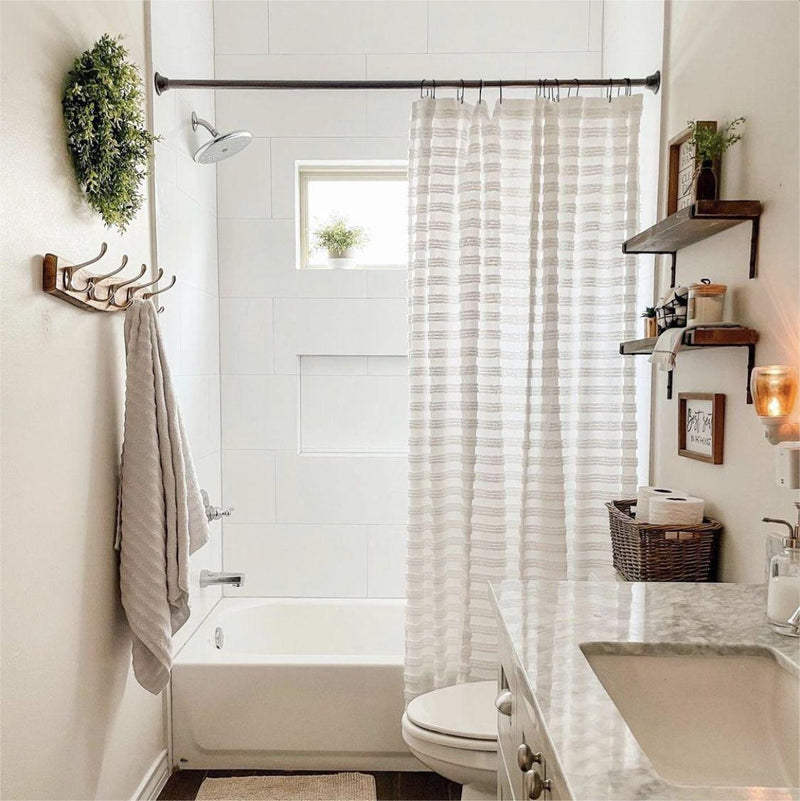 Bathroom with bathtub, shower curtain, and shelves.