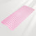 Pink bath mat with textured surface on a light gray background