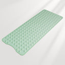 Green bath mat with textured surface on a light gray background