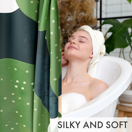 Woman in a bathtub with a green and black polka dot towel draped over her head, with text 'SILKY AND SOFT'.