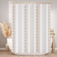 White shower curtain with gold geometric patterns in a bathroom setting.