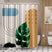 A shower curtain featuring an abstract design with geometric shapes and leaf patterns in beige, black, green, and orange colors.