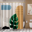 A shower curtain featuring an abstract design with geometric shapes and leaf patterns in beige, black, green, and orange colors.