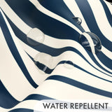 Blue and white striped fabric with water droplets demonstrating water repellent property.