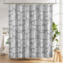 Shower curtain with black and white floral pattern in a bathroom setting