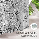 Black and white patterned shower curtain with text 'Weighted stones keep in place' on a bathroom setting.