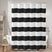 Black and white striped shower curtain in a bathroom setting.