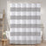 Striped shower curtain in a bathroom setting with bathtub and ladder.