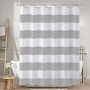 Striped shower curtain in a bathroom setting with bathtub and ladder.