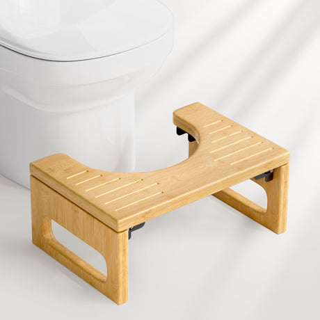 Wooden step stool in front of a white toilet on a light gray background