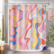 Colorful abstract patterned shower curtain in a bathroom setting.