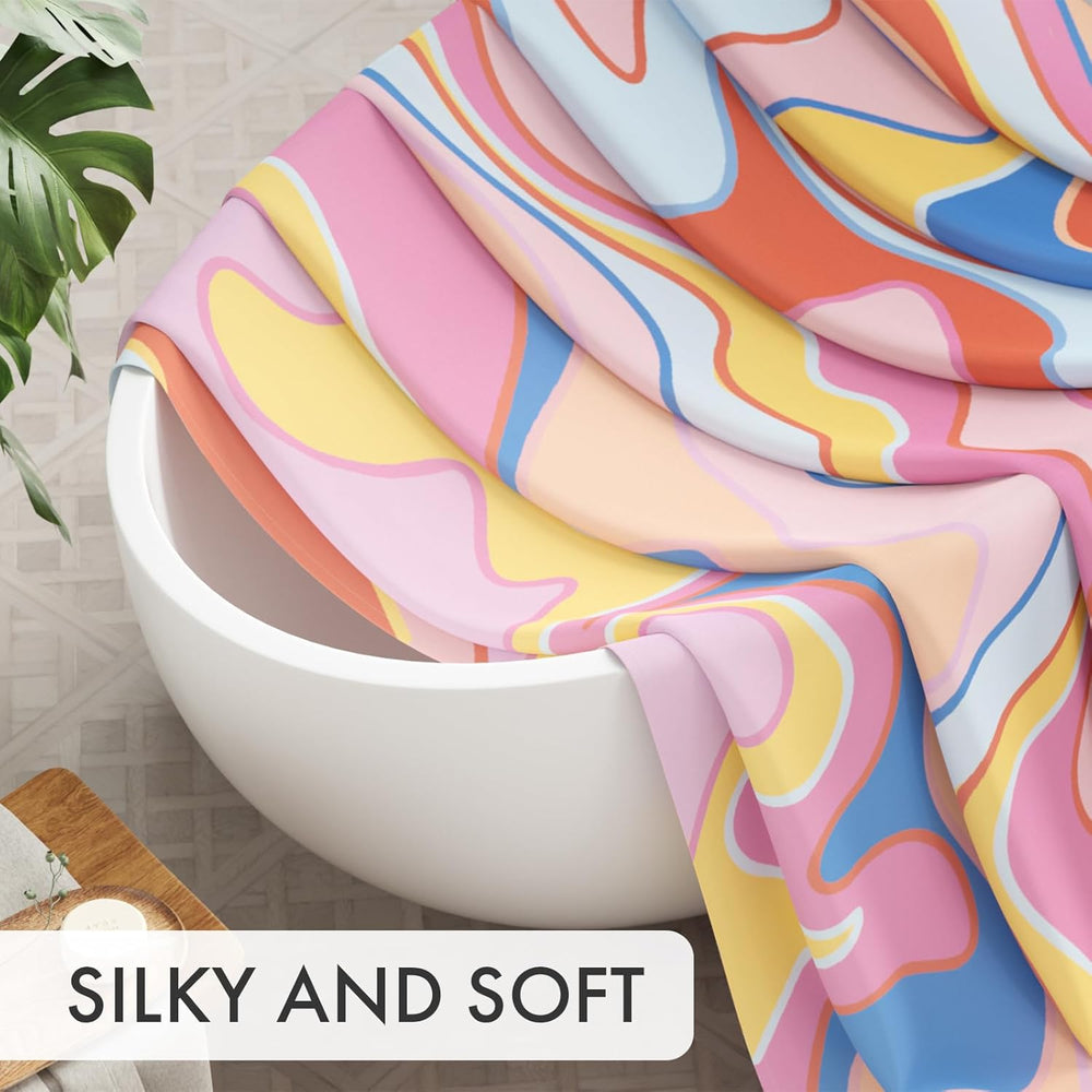 Colorful fabric draped over a white bowl with a plant and wooden board in the background, labeled 'SILKY AND SOFT'.