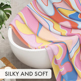 Colorful fabric draped over a white bowl with a plant and wooden board in the background, labeled 'SILKY AND SOFT'.