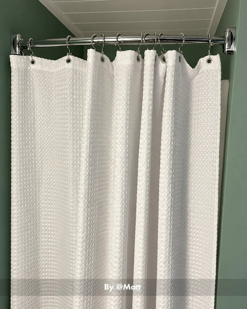 Customer bathroom photo showing a curved shower curtain rod installed above a tub, with the curved shape visible.