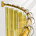 Gold shower curtain rod with decorative rings on a white background