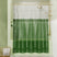 Green shower curtain with gold fixtures in a bathroom setting