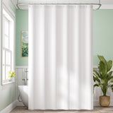 White shower curtain in a bathroom with green walls, a plant, and a bathtub.