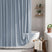 Bathroom with a blue shower curtain, white bathtub, and wooden stool.