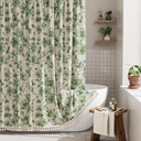 Bathroom with a green floral shower curtain, white bathtub, and wooden stool.
