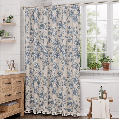 Floral patterned shower curtain in a bathroom with a window and wooden furniture.