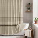 Bathroom with a striped shower curtain, bathtub, and wooden stool.