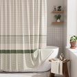 Striped shower curtain with green and white pattern in a bathroom setting.