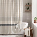 Bathroom with a striped shower curtain, bathtub, and wooden stool.