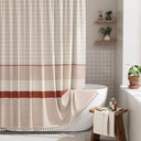 Bathroom with a striped shower curtain, bathtub, and wooden stool.