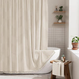 Bathroom with a white bathtub and textured shower curtain, wooden stool with towel, and plants.