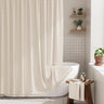 Bathroom with a white bathtub, shower curtain, and wooden stool.