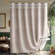 Beige shower curtain with white fringe in a bathroom setting