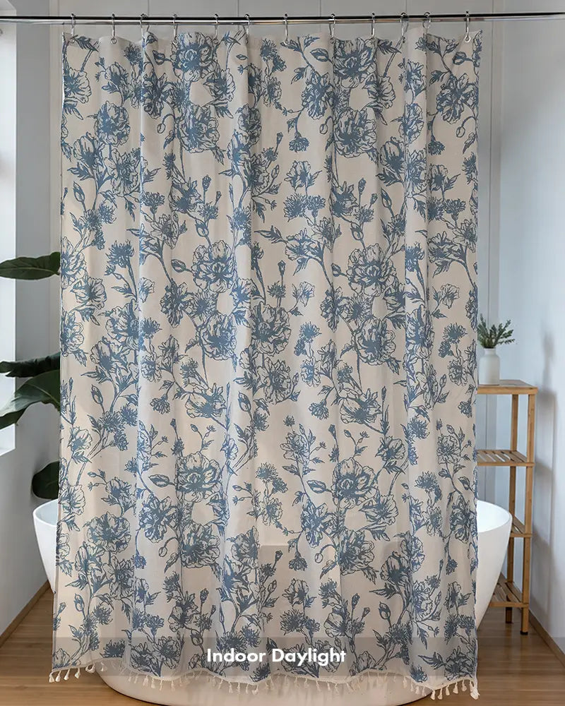 AmazerBath light blue floral tassel shower curtain with delicate botanical print and fringe beside a bathtub.