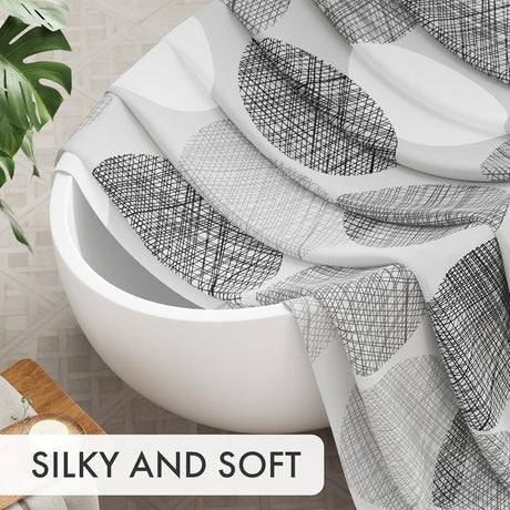 White bathtub with black geometric patterned towel draped over it, with text 'SILKY AND SOFT' at the bottom.