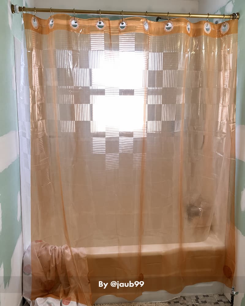 AmazerBath amber hookless Sun EVA shower curtain liner filtering window light above a white bathtub.