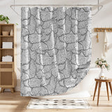 Shower curtain with black and white leaf pattern in a bathroom setting