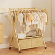 Wooden clothing rack with baby clothes and toys in a nursery setting