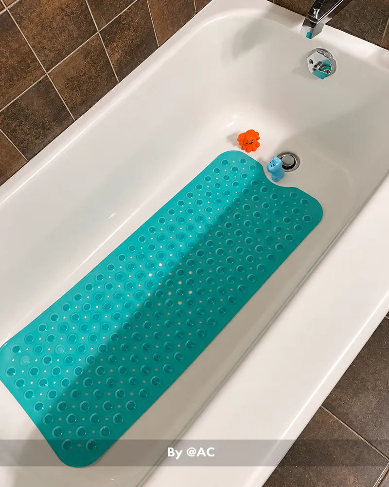 Customer bathroom photo showing a large bathtub mat placed beside or inside a tub, with the mat visible in the bath setting.