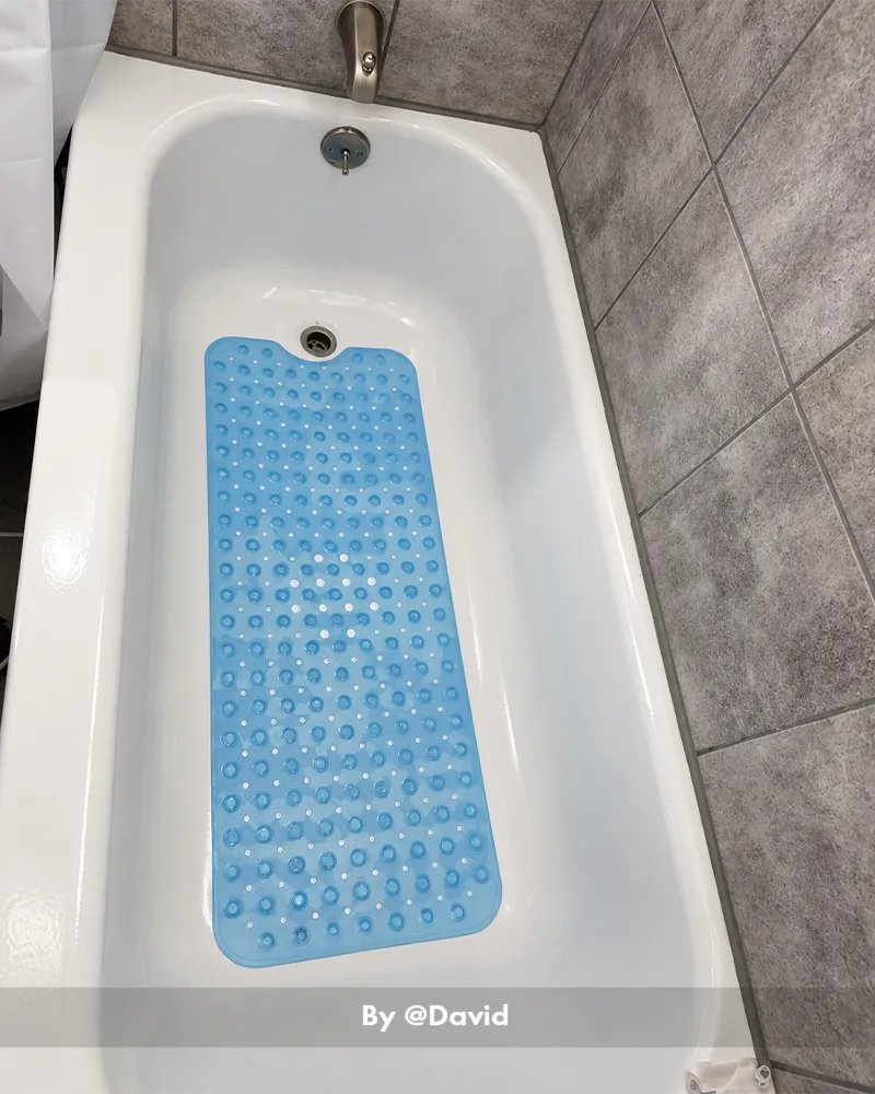 Customer bathroom photo showing a large bathtub mat placed beside or inside a tub, with the mat visible in the bath setting.