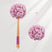 Pink bath pouf with wooden handle on a white background