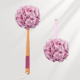 Pink bath pouf with wooden handle on a white background