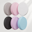 Set of six round, textured cleaning sponges in various colors on a light gray background