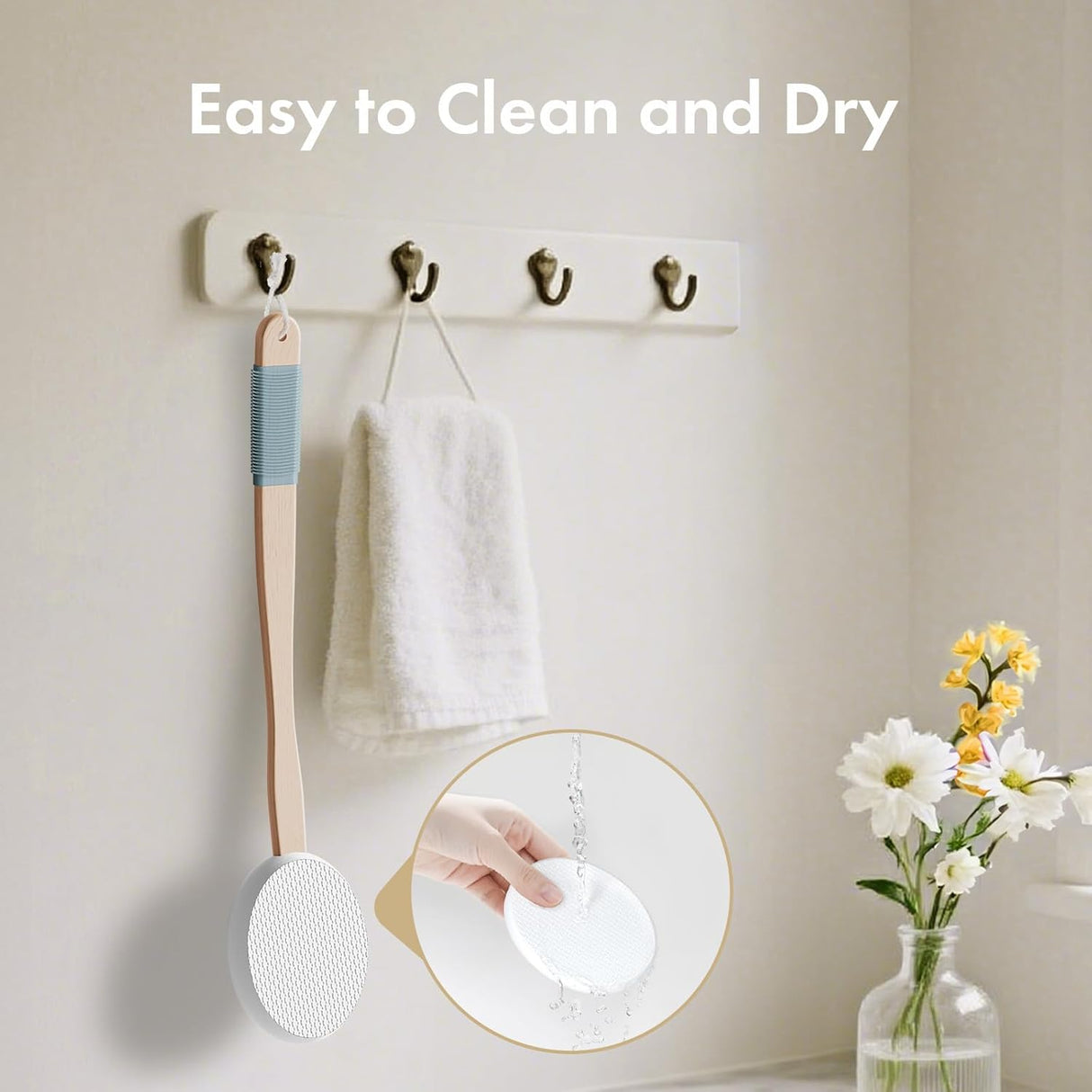 Wall-mounted hooks with a scrubber, towel, and small plant on a neutral background.