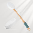 White spatula with wooden handle and blue silicone end on a light gray background