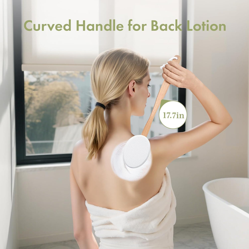 Woman applying lotion to her back with a curved handle applicator in a bathroom setting.
